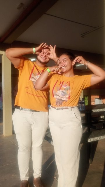Ana e Arthur fazendo poses divertidas com camisetas amarelas.